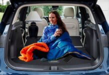 A person in a sleeping bag is shown in the trunk of a 2024 Buick Encore GX.