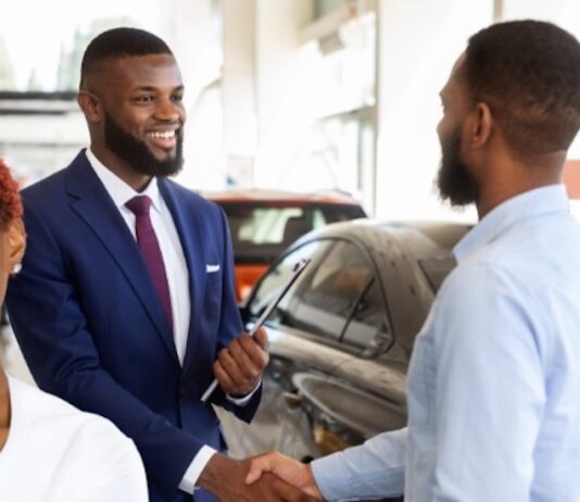 A customer is shown shaking a salesman's hand after buying a 2023 Honda CR-V Hybrid.