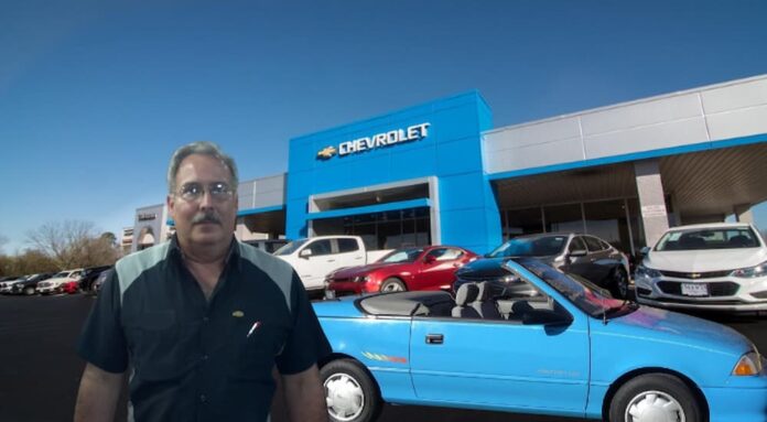 A person is shown standing in front a blue 1993 Geo Metro after trying to sell a 2024 Chevy Silverado 1500.