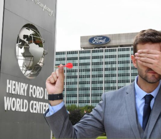 A person is shown holding a dart and covering his eyes from Live Auto News.