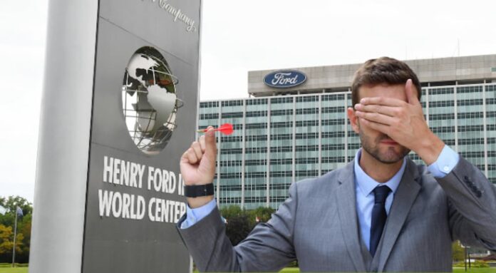 A person is shown holding a dart and covering his eyes from Live Auto News.