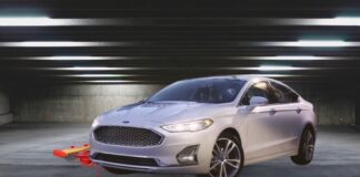A white 2020 Ford Fusion is shown from the front at an angle after leaving a used car dealer.