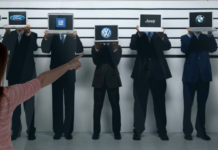 A police line-up of five men holding up laptops displaying the Ford, GM, Volkswagen, Jeep and BMW logos is shown.